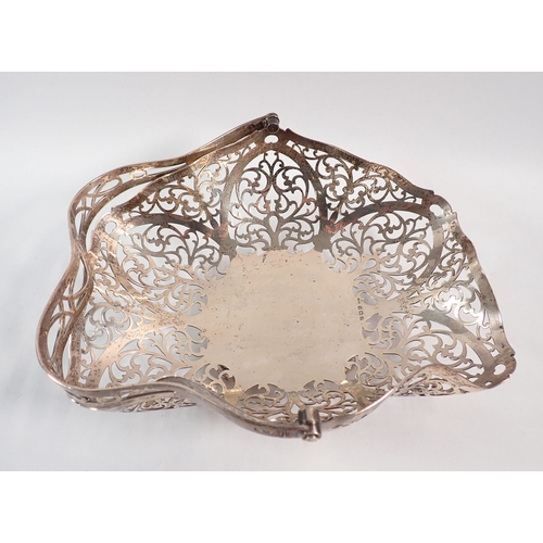 216 - A silver basket with pierced scrollwork decoration on ball feet by G Bryan & Co, Birmingham 1935, 22... 