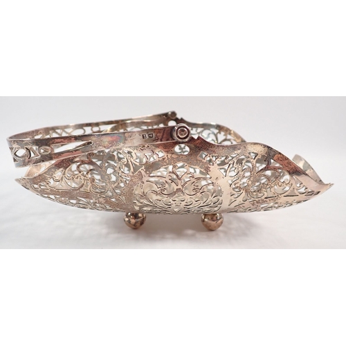 216 - A silver basket with pierced scrollwork decoration on ball feet by G Bryan & Co, Birmingham 1935, 22... 