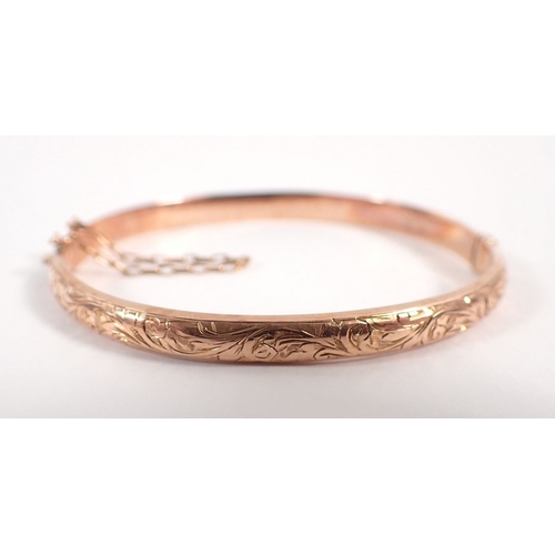 275 - A 9 carat gold engraved hinged bangle, 6cm diameter in original case, 5.8g