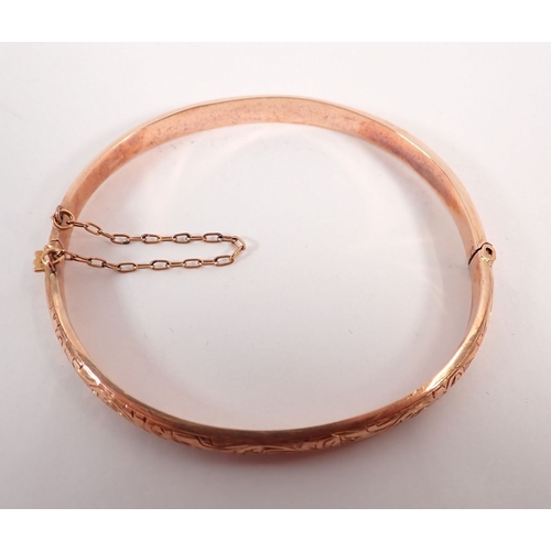275 - A 9 carat gold engraved hinged bangle, 6cm diameter in original case, 5.8g