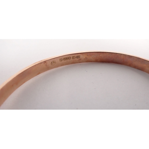 275 - A 9 carat gold engraved hinged bangle, 6cm diameter in original case, 5.8g