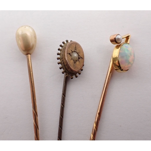 279 - A gold opal and pearl stick pin, a 9 carat gold stick pin and one other unmarked, total 4g