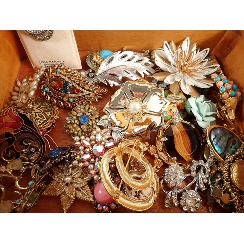 405 - A box of various costume jewellery including brooches etc.