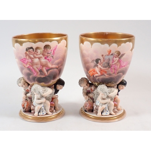 132 - A pair of 19th century Berlin gilt porcelain goblets painted reserves of cherubs in the clouds on fi... 
