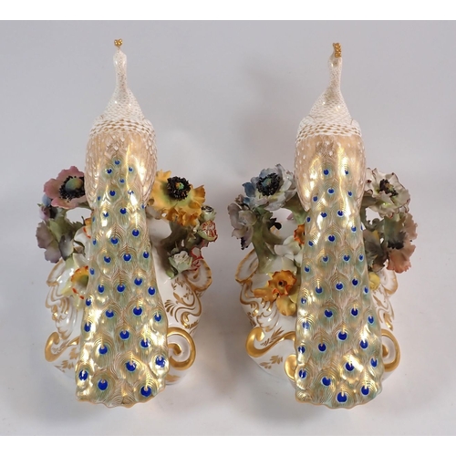 147 - A Royal Crown Derby pair of peacocks on floral bases, 18cm high, one signed J.Brown, one signed V.E.... 