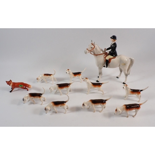 149 - A Beswick set of seven hounds and a fox plus a huntswoman (leg a/f) 21.5cm tall, and another hound a... 