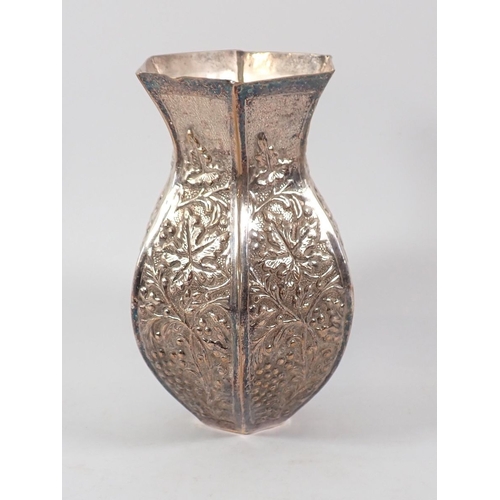 182 - A white metal octagonal vase with embossed foliate decoration, 18cm high
