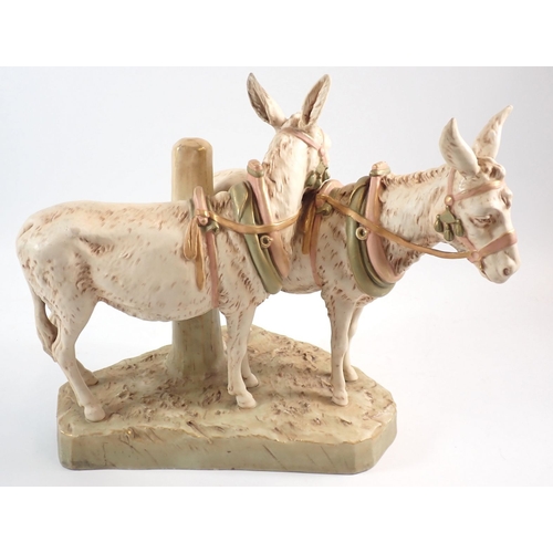19 - A Royal Dux pair of donkeys wearing tack, 30cm high