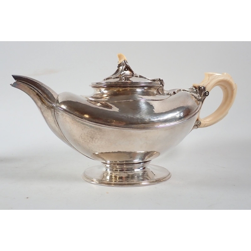 207 - An Omar Ramsden Arts & Crafts silver three piece tea service of naturalistic oval form on pedestal f... 
