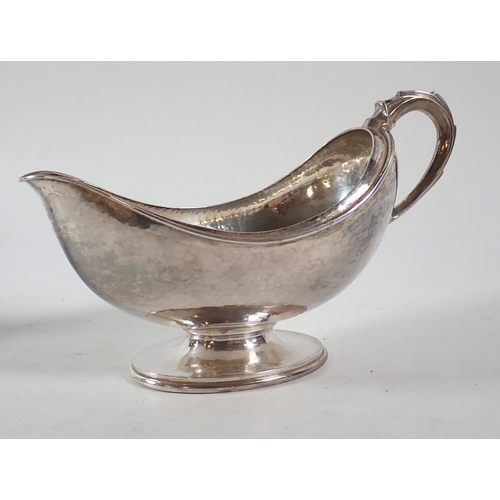 207 - An Omar Ramsden Arts & Crafts silver three piece tea service of naturalistic oval form on pedestal f... 