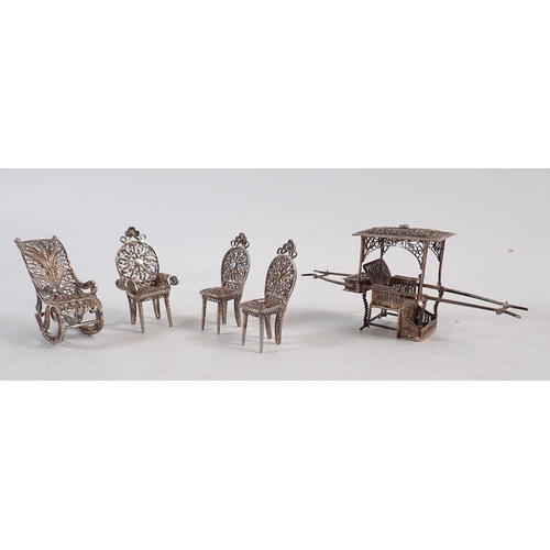 221 - A white metal filigree rickshaw, two boats and four miniature chairs, tallest item 12cm high