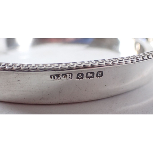 226 - Two silver circular dishes, 10cm diameter and a silver baby feeding spoon, total weight 111g