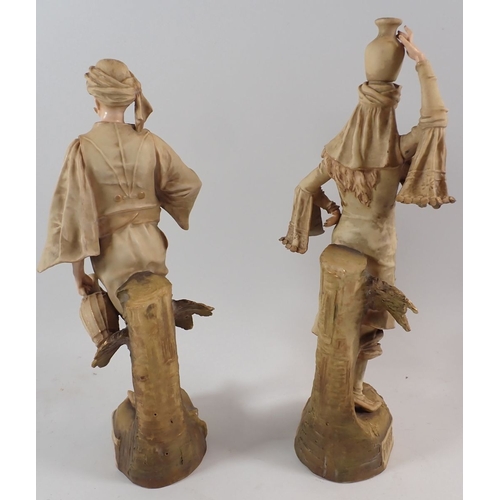 23 - A pair of figures of water carrier and her companion, 34cm high