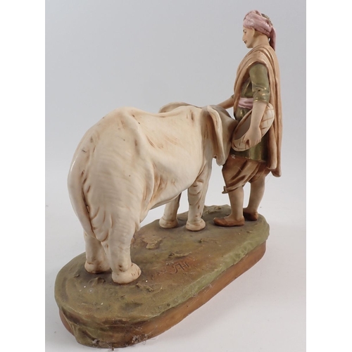 24 - A Royal Dux group of an elephant calf and Mahout, 25cm high