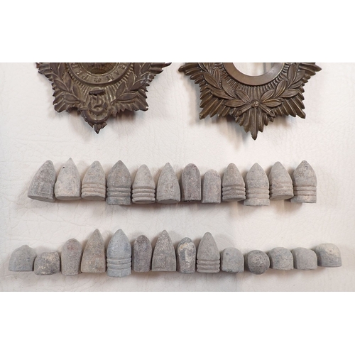606 - A collection of relics to the Crimea War - spent bullets with various period helmet plates, Russia a... 