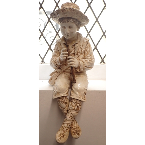 23 - A Bretby large pottery figure of a seated boy with flute - head repaired, fingers a/f 55cm tall