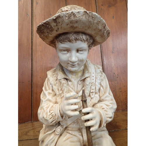 23 - A Bretby large pottery figure of a seated boy with flute - head repaired, fingers a/f 55cm tall