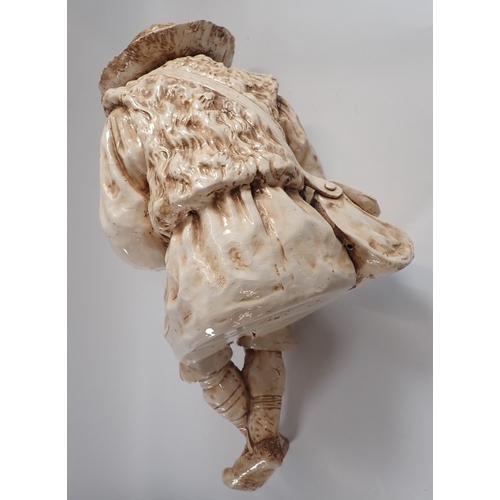 23 - A Bretby large pottery figure of a seated boy with flute - head repaired, fingers a/f 55cm tall