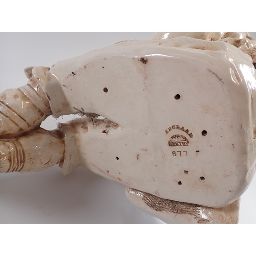 23 - A Bretby large pottery figure of a seated boy with flute - head repaired, fingers a/f 55cm tall