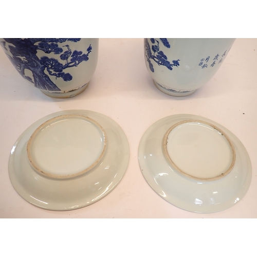 5 - A pair of Chinese blue and white jardinieres decorated cranes each on a Chinese blue and white plate... 