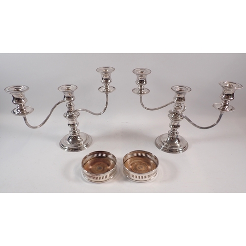 250 - A pair of silver plated candelabra, 24cm tall and a pair of bottle coasters