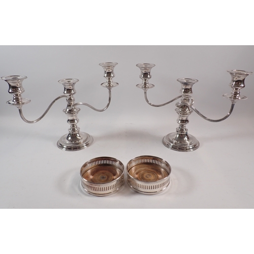 250 - A pair of silver plated candelabra, 24cm tall and a pair of bottle coasters