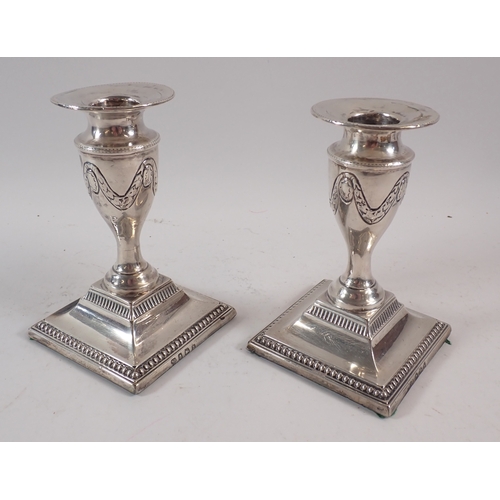 258 - A pair of silver urn form candlesticks with swag decoration, Birmingham 1907 Charles Boyton & Son Lt... 