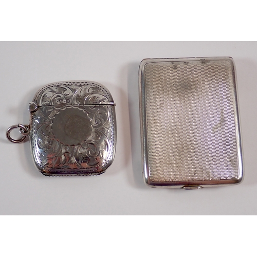 277 - An Edwardian silver vesta case with circular cartouche and engraved scrollwork decoration by William... 