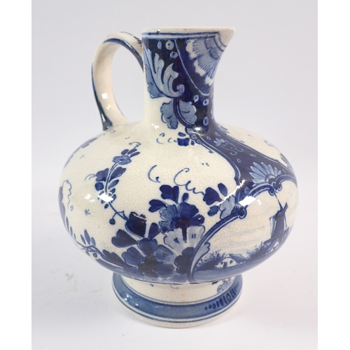 37 - A Delft blue and white jug with bulbous squat body painted flowers and windmill, 17cm tall