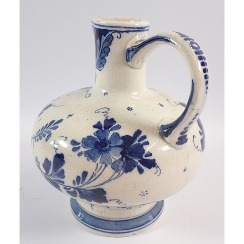 37 - A Delft blue and white jug with bulbous squat body painted flowers and windmill, 17cm tall