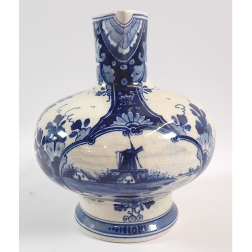 37 - A Delft blue and white jug with bulbous squat body painted flowers and windmill, 17cm tall