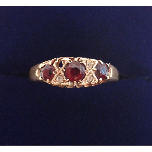 377 - A 9 carat gold three stone garnet ring with diamond accents, one deficient, size T, 2.1g