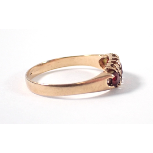377 - A 9 carat gold three stone garnet ring with diamond accents, one deficient, size T, 2.1g