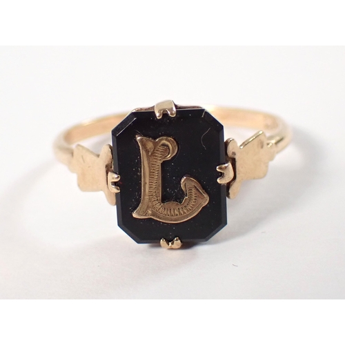 386 - A 9ct gold ring set emerald cut onyx applied gold initial 'L' size N-O, 2g