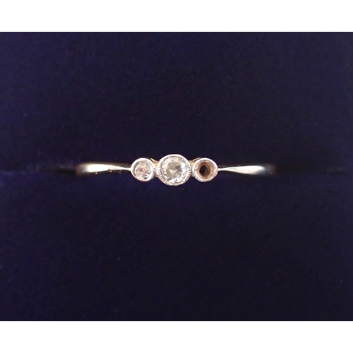 387 - An 18ct gold platinum three stone diamond ring, one diamond deficient, size P-Q, 1.5g