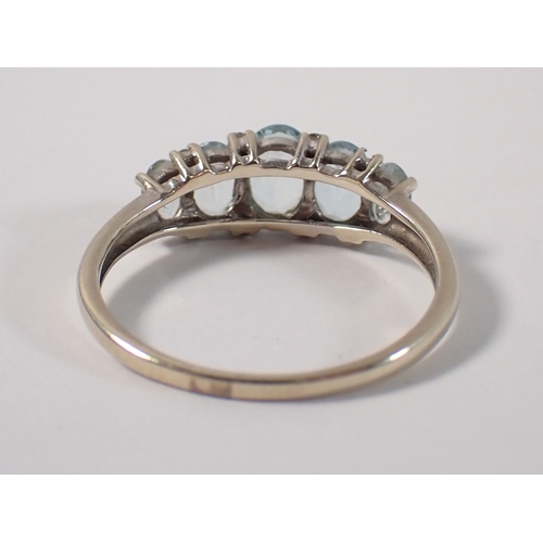 388 - A 9ct gold five stone aquamarine ring with chip diamond accents, size U, 2.7g