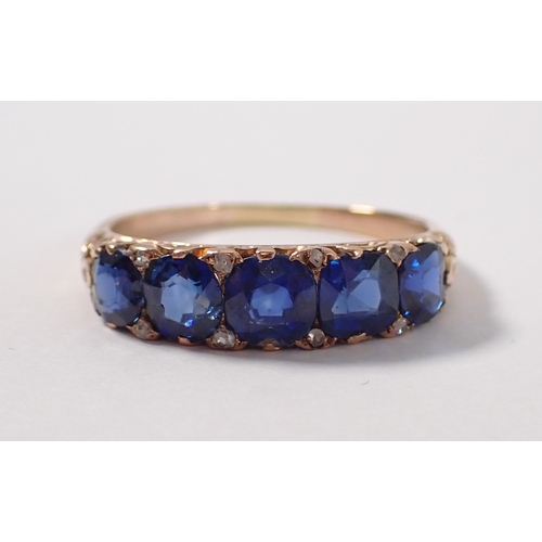389 - An unmarked gold ring set five sapphires with diamond accents, size Q/R, 3.2g, tested as 9 carat