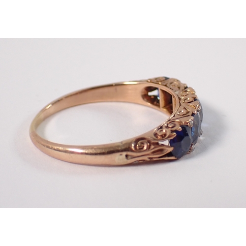 389 - An unmarked gold ring set five sapphires with diamond accents, size Q/R, 3.2g, tested as 9 carat