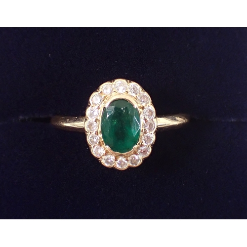399 - An 18ct gold ring set emerald within diamond surround, size M, 3g