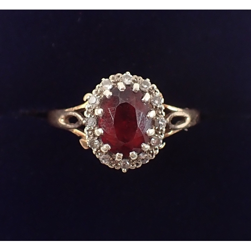 400 - A 9ct gold ring set garnet within diamond surround, size P, 3g
