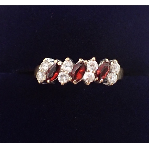 402 - A 9ct gold ring set three garnets interspersed pairs of white stones, size N, 2.2g
