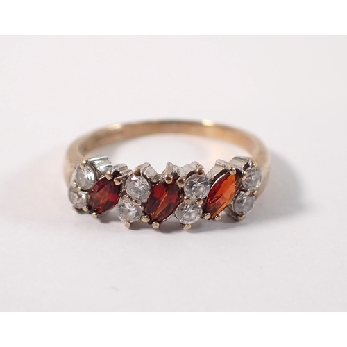 402 - A 9ct gold ring set three garnets interspersed pairs of white stones, size N, 2.2g