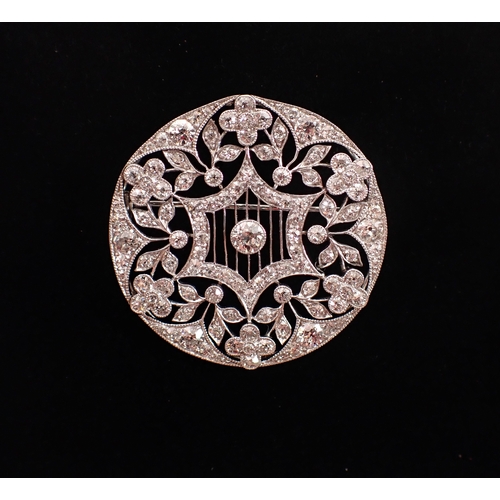 405 - A platinum circular brooch set diamond openwork star and flowerhead design, 3.5cm diameter, 10.3g