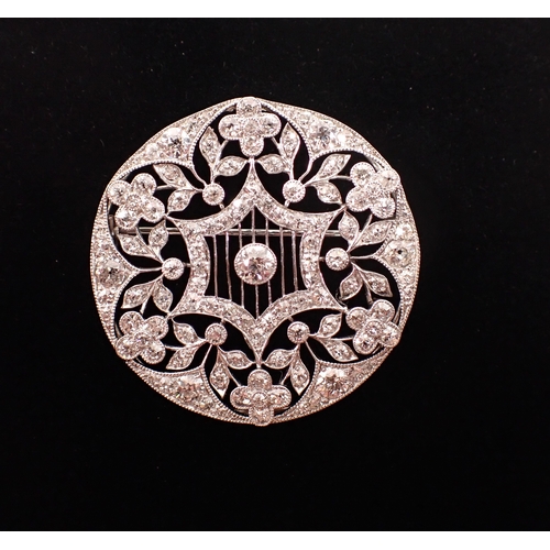 405 - A platinum circular brooch set diamond openwork star and flowerhead design, 3.5cm diameter, 10.3g