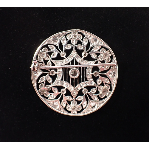 405 - A platinum circular brooch set diamond openwork star and flowerhead design, 3.5cm diameter, 10.3g