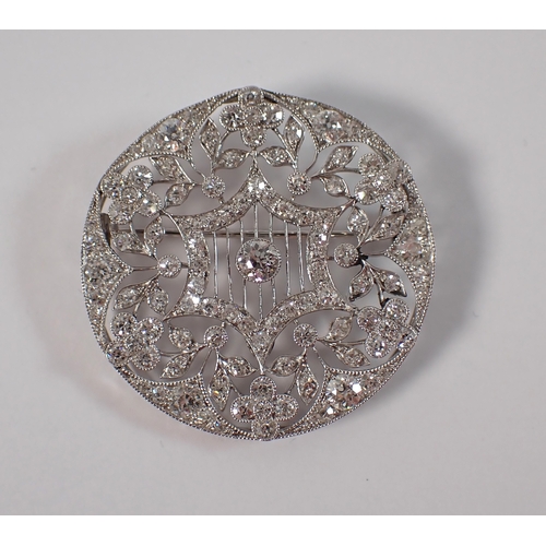 405 - A platinum circular brooch set diamond openwork star and flowerhead design, 3.5cm diameter, 10.3g