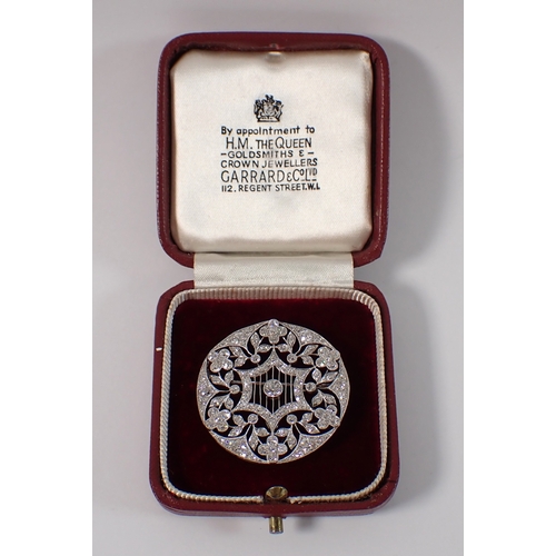 405 - A platinum circular brooch set diamond openwork star and flowerhead design, 3.5cm diameter, 10.3g