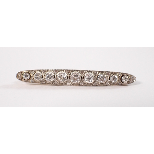 406 - An 18ct yellow and white metal bar brooch set graduated row of nine diamonds, central diamond 3.6mm,... 