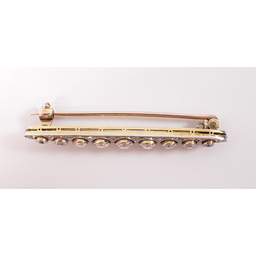 406 - An 18ct yellow and white metal bar brooch set graduated row of nine diamonds, central diamond 3.6mm,... 