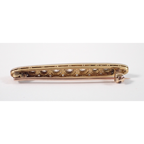 406 - An 18ct yellow and white metal bar brooch set graduated row of nine diamonds, central diamond 3.6mm,... 